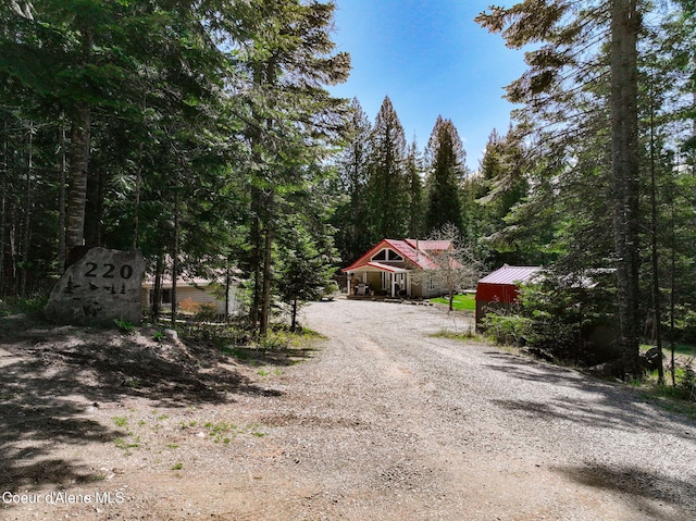 view of road featuring driveway and a forest view