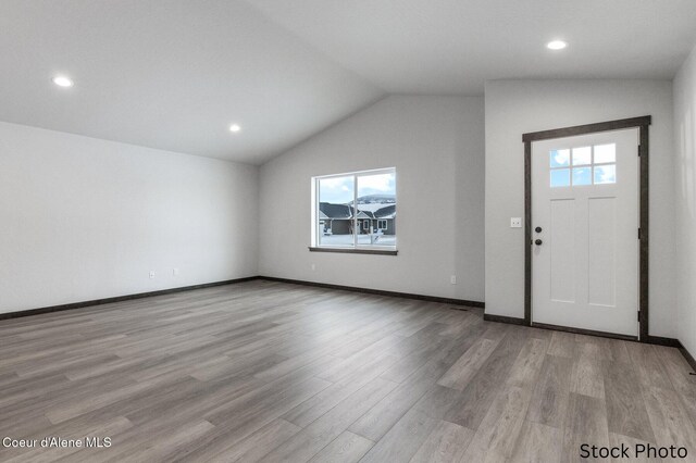 entryway featuring baseboards, lofted ceiling, wood finished floors, and recessed lighting