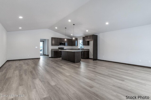 kitchen with open floor plan, light countertops, a center island, dark brown cabinetry, and appliances with stainless steel finishes