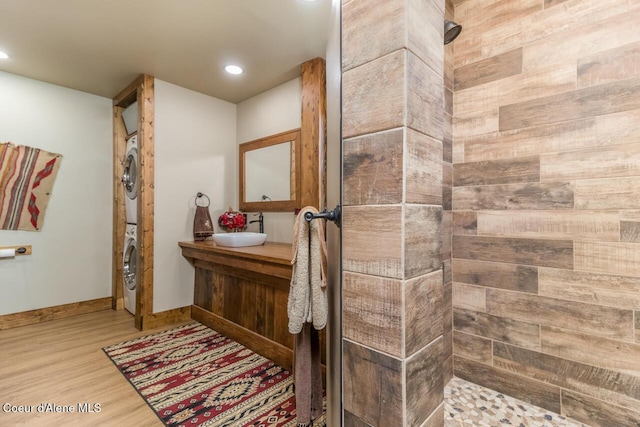 488 Fawn Ln, Bonners Ferry, ID 83805 - bathroom featuring stacked washer / drying machine, recessed lighting, wood finished floors, vanity, and tiled shower