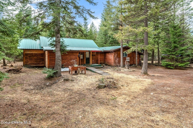 back of property with faux log siding and metal roof