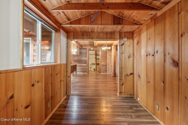 corridor with lofted ceiling, wooden ceiling, a chandelier, wooden walls, and wood finished floors