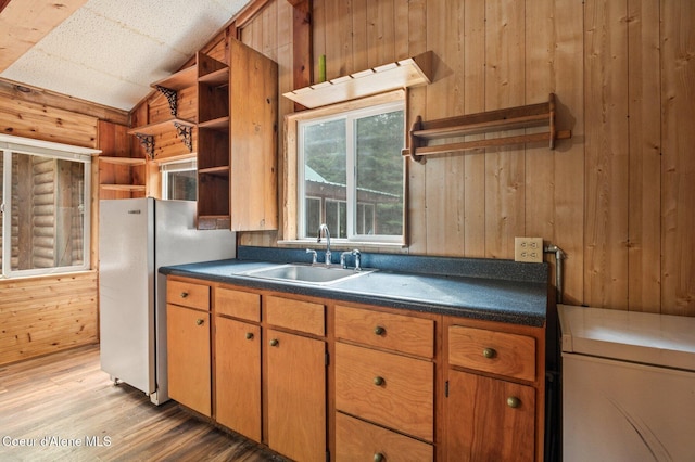 kitchen featuring a sink, open shelves, dark countertops, and wood walls