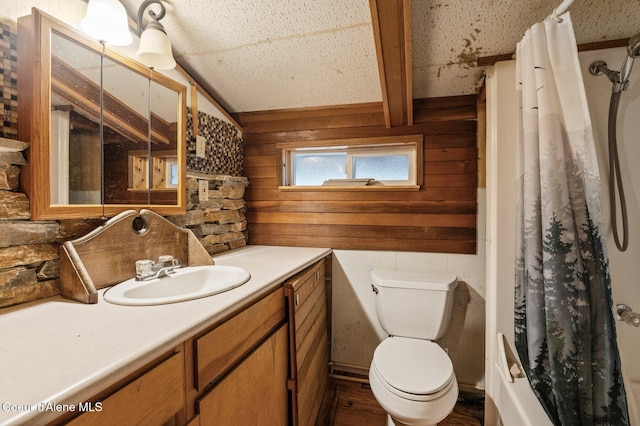 full bath featuring wood walls, toilet, vanity, a shower with curtain, and lofted ceiling