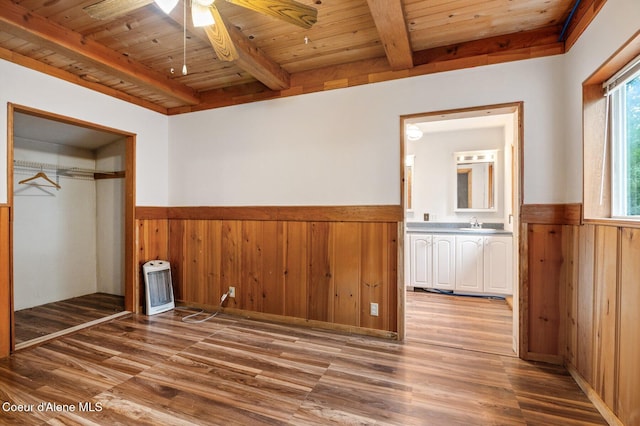 unfurnished bedroom featuring wainscoting, wood walls, beam ceiling, and wood ceiling