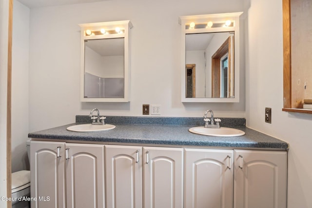 full bath featuring double vanity, toilet, and a sink