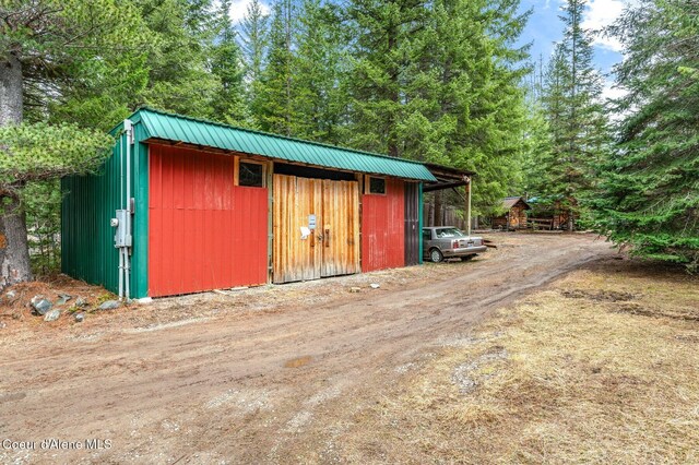 view of outdoor structure with an outbuilding and dirt driveway