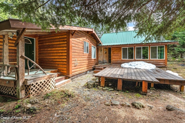 rear view of property featuring metal roof and log veneer siding