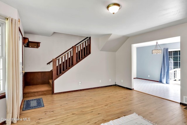 12854 E Hellroaring Rd, Athol, ID 83801 - unfurnished living room with stairway, wood finished floors, and baseboards