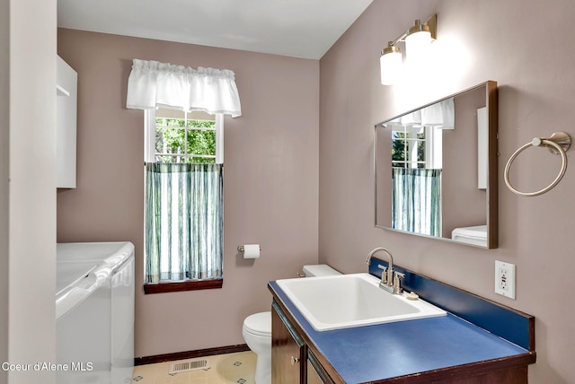 12854 E Hellroaring Rd, Athol, ID 83801 - bathroom featuring washing machine and dryer, toilet, vanity, and baseboards