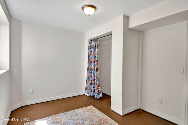 12854 E Hellroaring Rd, Athol, ID 83801 - unfurnished bedroom with finished concrete flooring, baseboards, and a closet