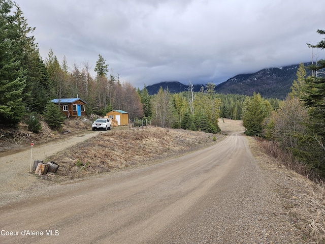 view of road with a mountain view and a view of trees