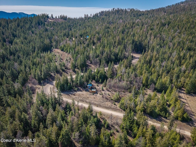 birds eye view of property featuring a wooded view and a mountain view