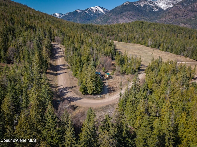 aerial view featuring a wooded view and a mountain view