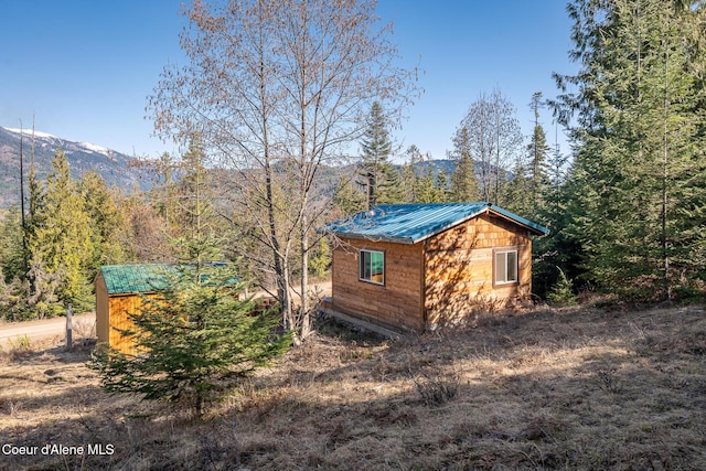 view of outbuilding with a wooded view and an outdoor structure