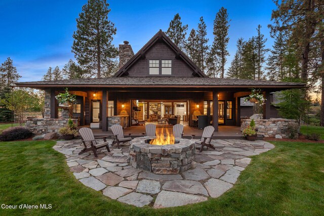 2623 E Old Barn Ct, Harrison, ID 83833 - rear view of house with a patio, a chimney, a fire pit, and a lawn