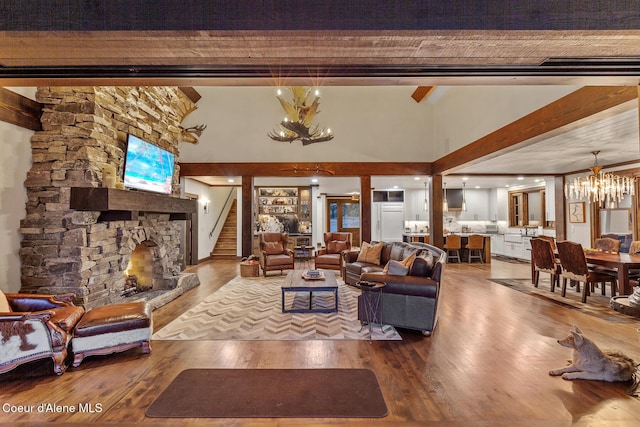 2623 E Old Barn Ct, Harrison, ID 83833 - living room with a fireplace, wood finished floors, a towering ceiling, and an inviting chandelier