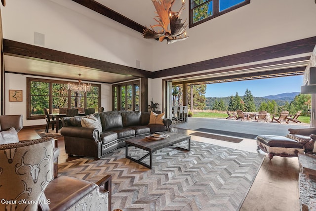2623 E Old Barn Ct, Harrison, ID 83833 - living room with a high ceiling, wood finished floors, a healthy amount of sunlight, and a notable chandelier