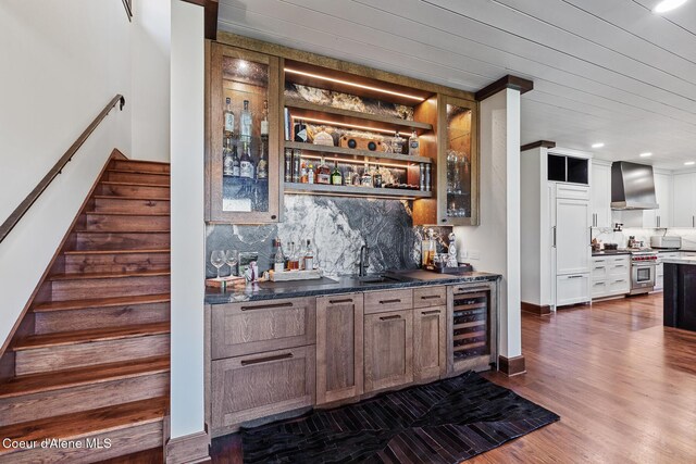 2623 E Old Barn Ct, Harrison, ID 83833 - bar featuring stairs, wall chimney exhaust hood, wet bar, high end stainless steel range oven, and beverage cooler