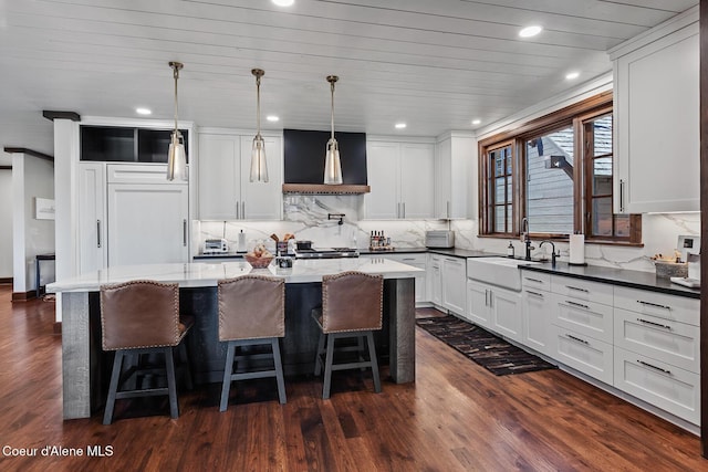 2623 E Old Barn Ct, Harrison, ID 83833 - kitchen featuring a kitchen island, a sink, dark wood-type flooring, and wall chimney exhaust hood