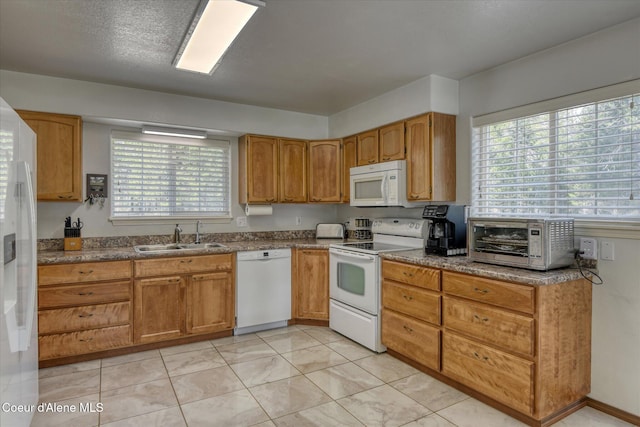 kitchen featuring a sink, brown cabinets, white appliances, dark countertops, and a toaster