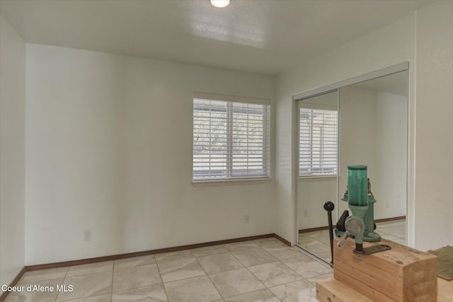 empty room featuring light tile patterned floors and baseboards