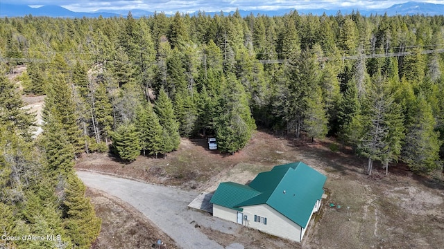 aerial view featuring a wooded view and a mountain view
