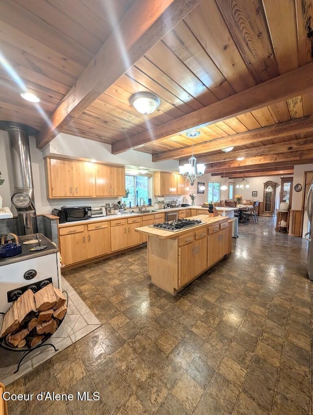 kitchen with light countertops, wooden ceiling, stainless steel gas stovetop, and light brown cabinets