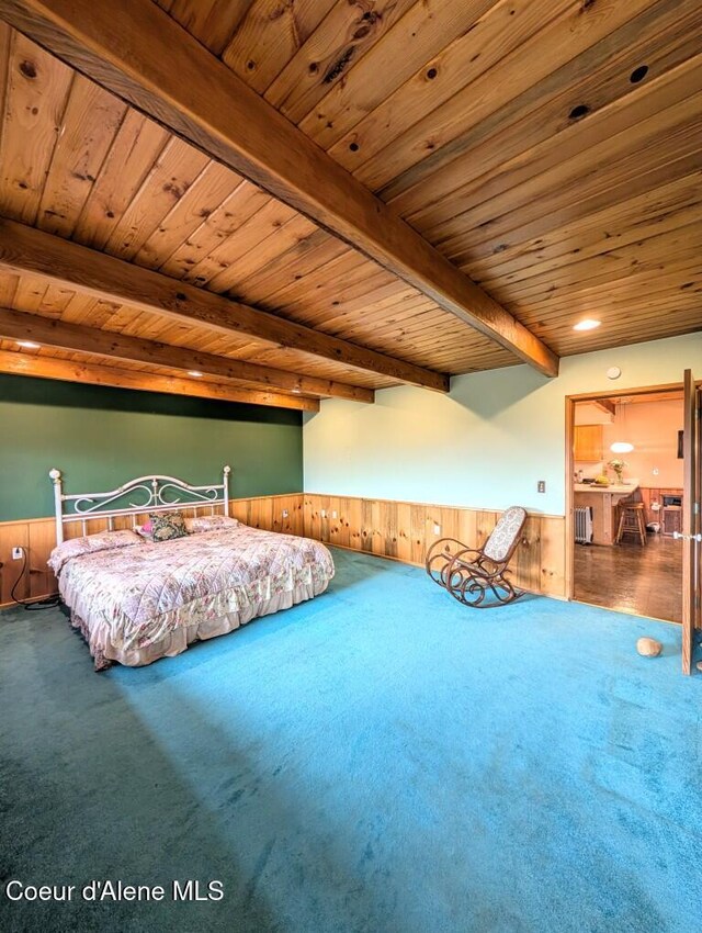 bedroom featuring carpet floors, wood walls, a wainscoted wall, beamed ceiling, and wood ceiling