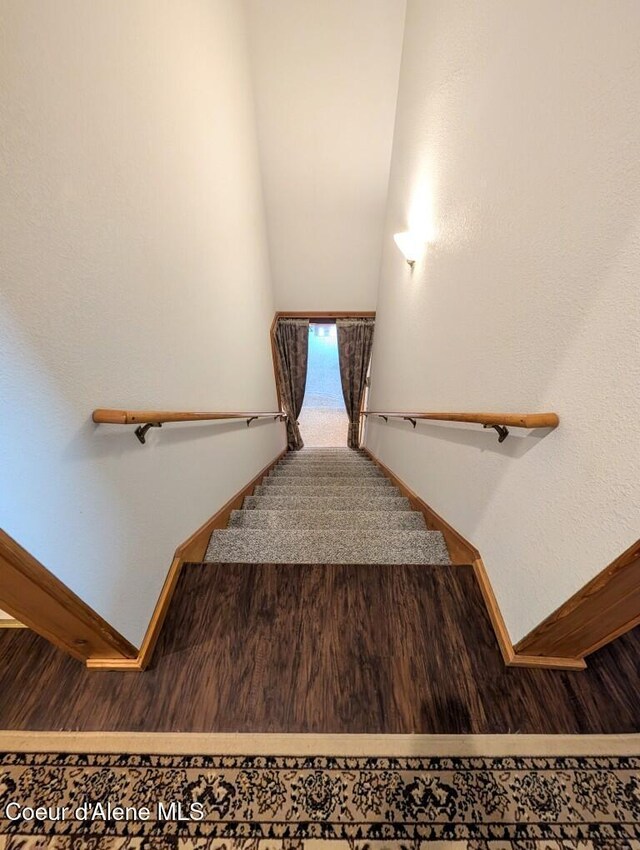 stairway with baseboards and wood finished floors