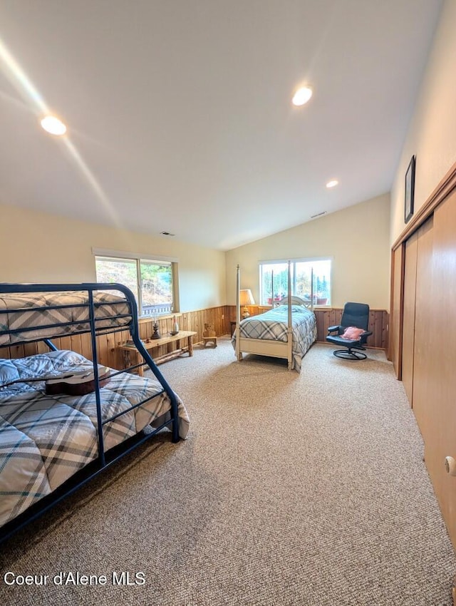 carpeted bedroom featuring recessed lighting, wood walls, wainscoting, and a closet