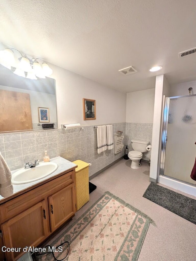 full bath featuring visible vents, a stall shower, toilet, and vanity