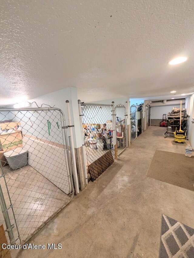 misc room with a textured ceiling and unfinished concrete flooring