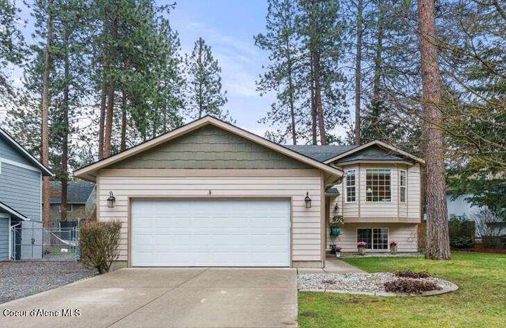 view of front of home with a front lawn, concrete driveway, and an attached garage
