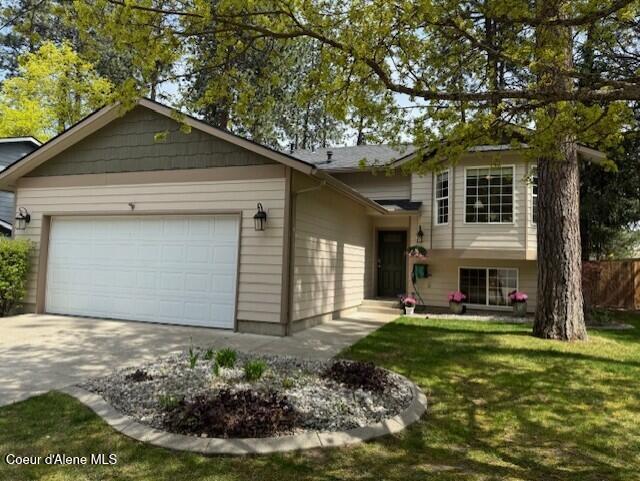 303 S Aerie Ct, Post Falls, ID 83854 - tri-level home featuring fence, concrete driveway, a front yard, and a garage