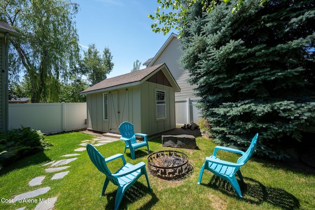 687 E Round Up Cir, Hayden, ID 83835 - fenced backyard with an outdoor fire pit and an outbuilding