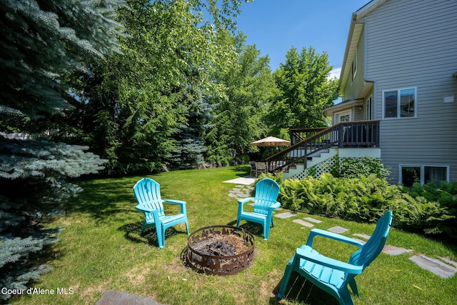 687 E Round Up Cir, Hayden, ID 83835 - view of green lawn with an outdoor fire pit, stairway, and a wooden deck