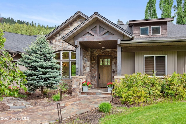 1990 S Gateway Ranch Rd, Coeur Dalene, ID 83814 - doorway to property with a shingled roof, stone siding, and covered porch
