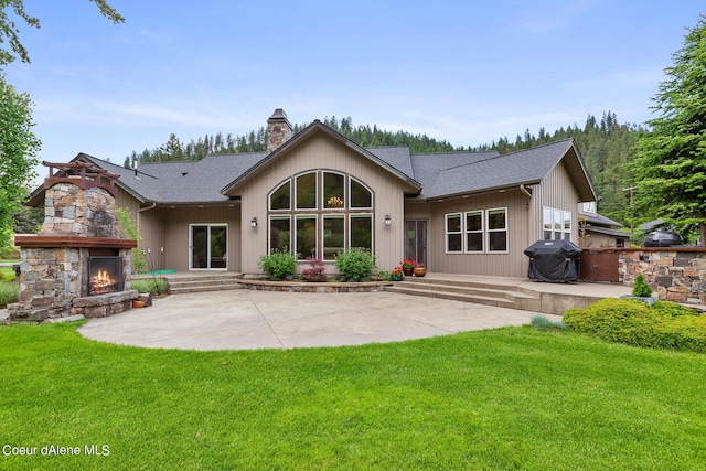 1990 S Gateway Ranch Rd, Coeur Dalene, ID 83814 - rear view of property with a patio, roof with shingles, an outdoor stone fireplace, and a chimney