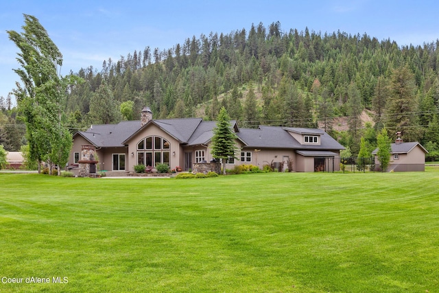 1990 S Gateway Ranch Rd, Coeur Dalene, ID 83814 - back of property with a view of trees, a lawn, and a chimney
