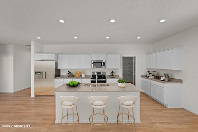 5181 E Aquila Ave, Post Falls, ID 83854 - kitchen with stainless steel appliances, a breakfast bar, a sink, and light wood finished floors