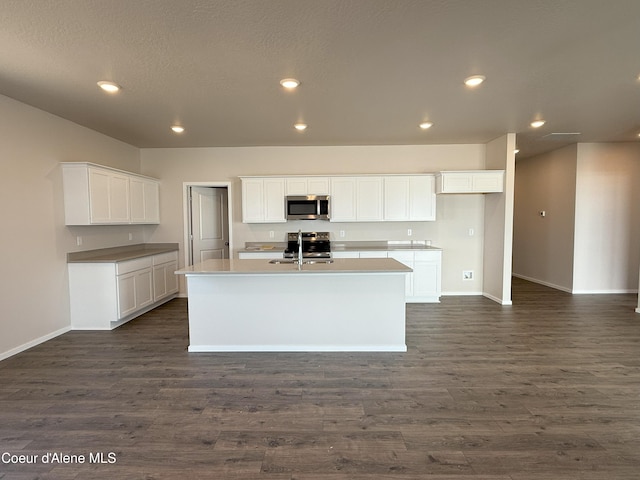 5181 E Aquila Ave, Post Falls, ID 83854 - kitchen featuring appliances with stainless steel finishes, baseboards, dark wood-style flooring, and an island with sink