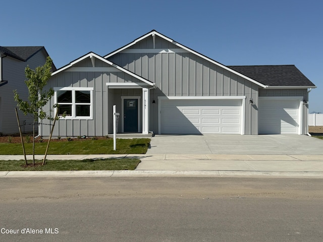 5181 E Aquila Ave, Post Falls, ID 83854 - view of front of house with a garage, board and batten siding, concrete driveway, and roof with shingles