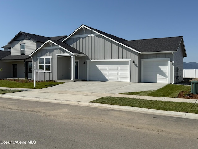 5181 E Aquila Ave, Post Falls, ID 83854 - view of front of property featuring a garage, board and batten siding, driveway, and roof with shingles