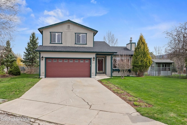 traditional-style home with a garage, driveway, fence, and a front lawn