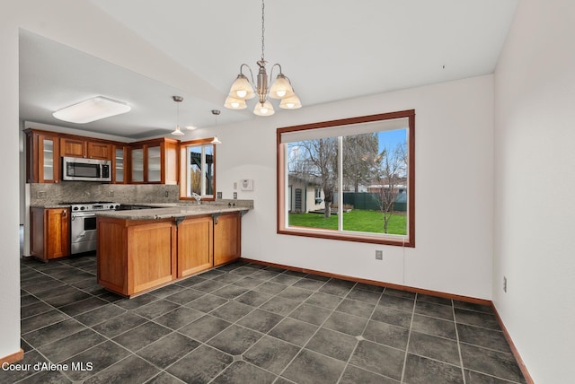 kitchen with glass insert cabinets, a peninsula, a chandelier, stainless steel appliances, and backsplash