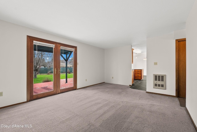 unfurnished living room with baseboards, heating unit, and carpet flooring