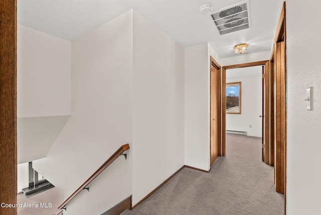corridor with visible vents, carpet floors, baseboard heating, an upstairs landing, and baseboards