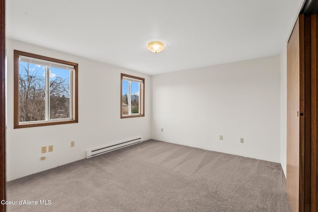 unfurnished room with carpet floors and a baseboard heating unit
