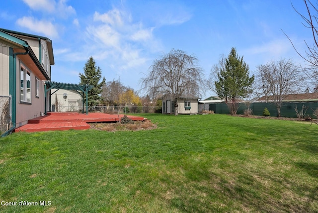 view of yard with an outdoor structure, a pergola, a shed, a fenced backyard, and a wooden deck